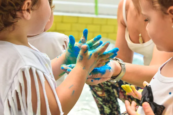 Crianças brincando com tinta nas mãos