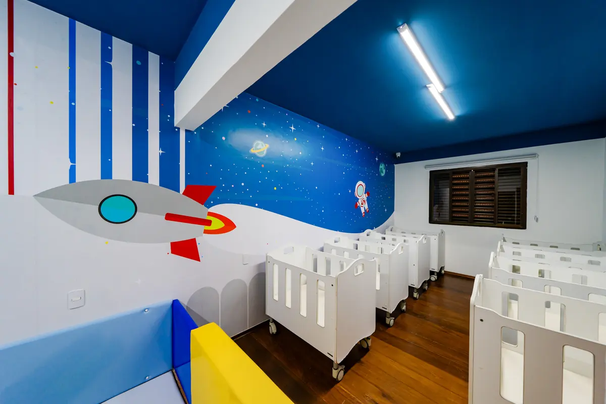 Área de soninho do B1, com berços individuais e teto azul estrelado